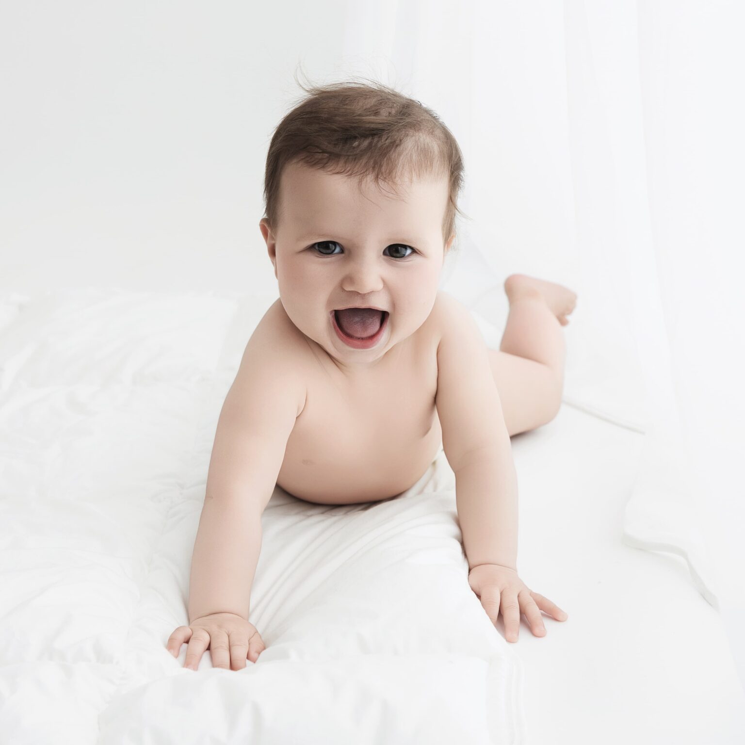Bébé à plat ventre en culotte, il sourit lors de sa séance première année