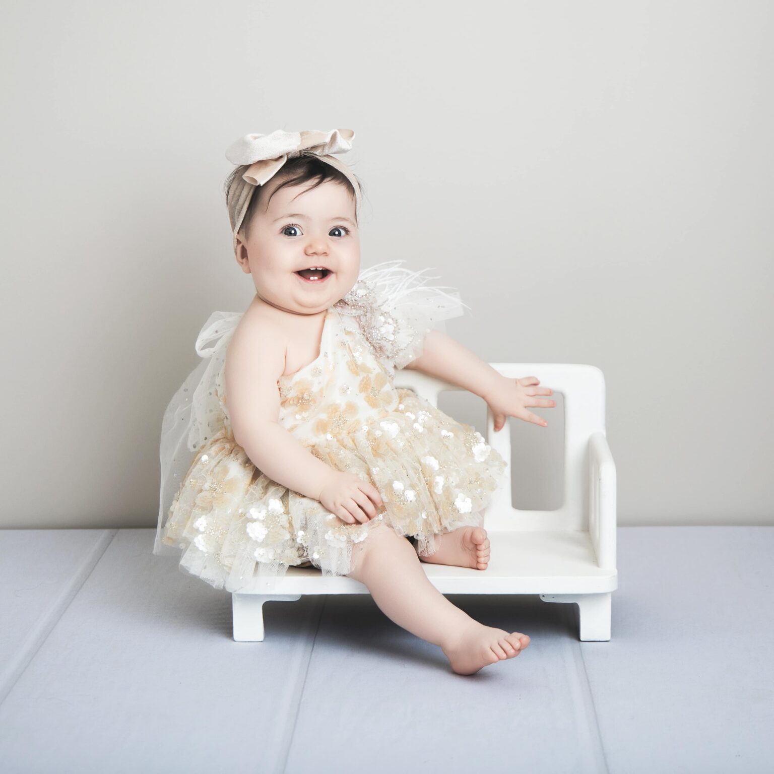 Bébé en beige, elle porte une robe couture du dressing.